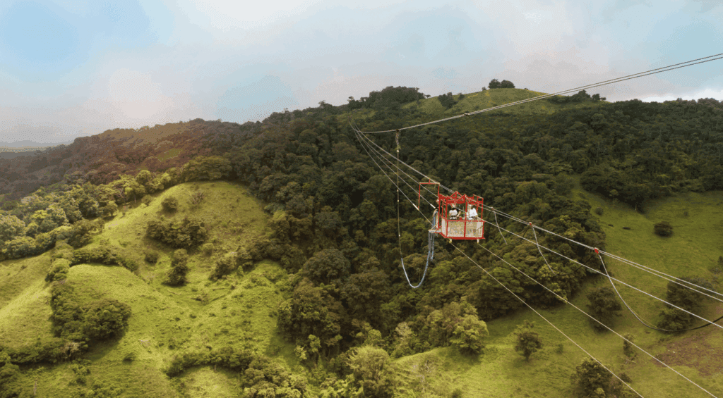 Turistas em plataforma suspensa para bungee jump sobre a floresta nublada na Costa Rica.